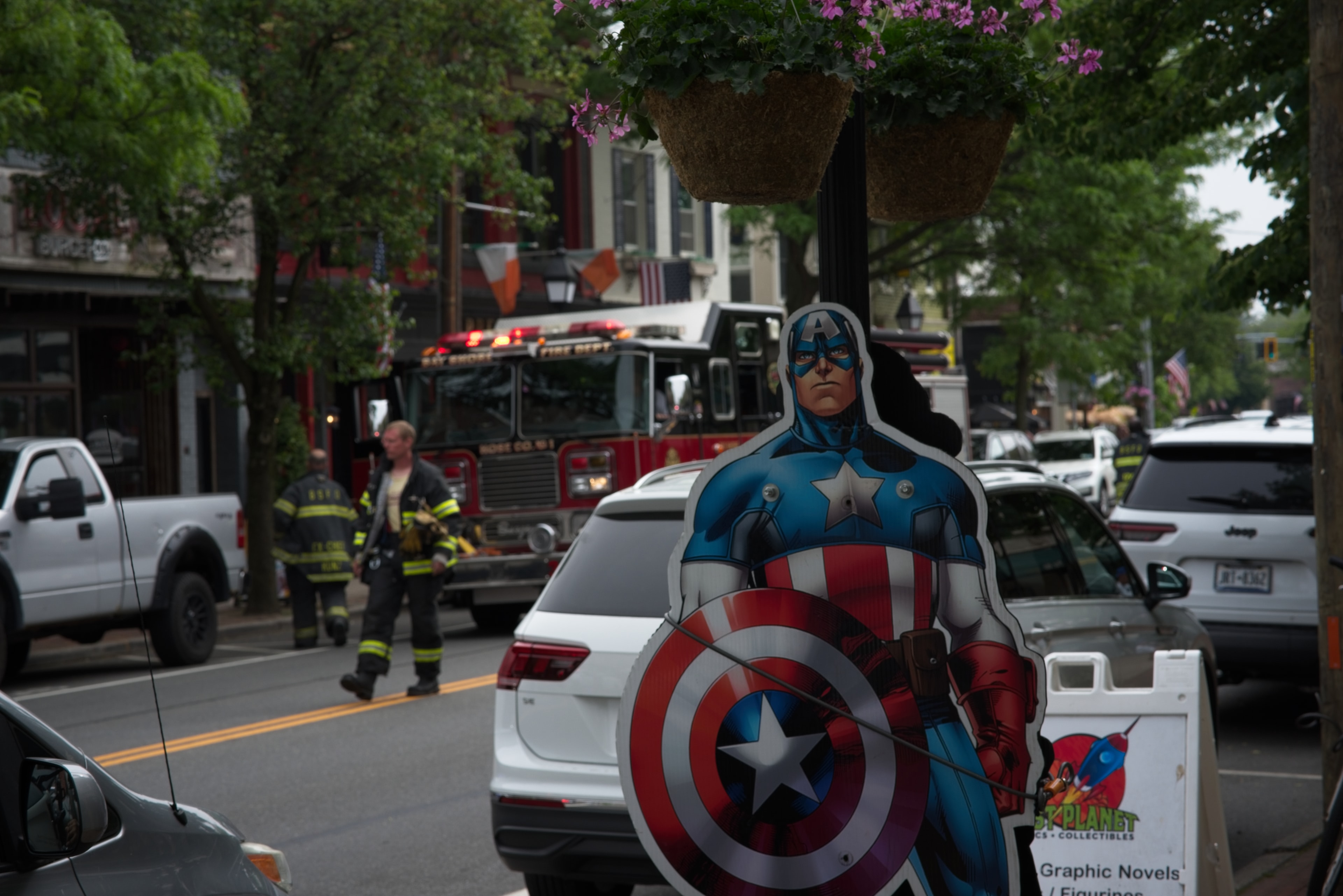 Captain America cutout on a street with a fire truck and firefighter in the background
